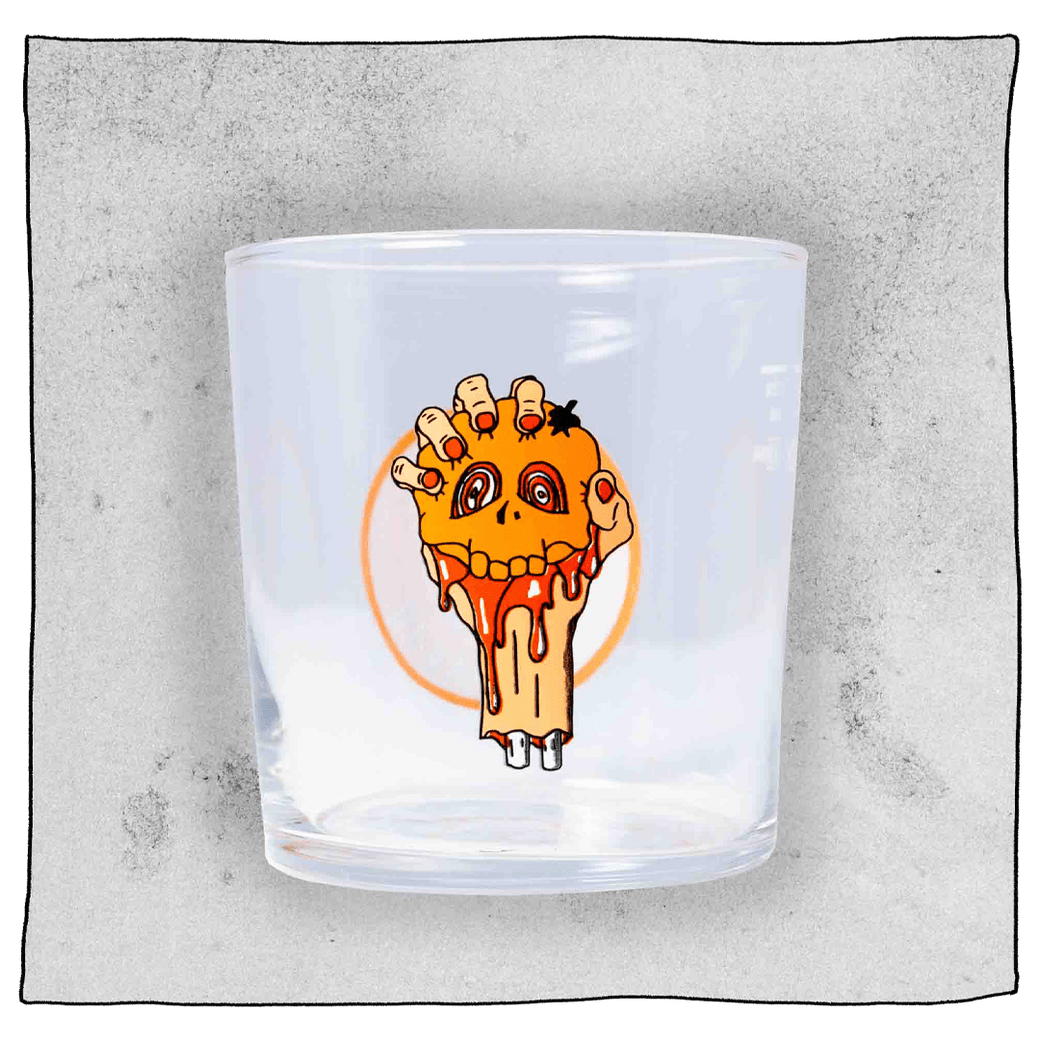 Beavertown Blood E'll Half pint glass. Blood E'll half pint glass is empty and contains a logo of a bloody severed arm with orange fingernails clenching a small orange skull. Grey background.