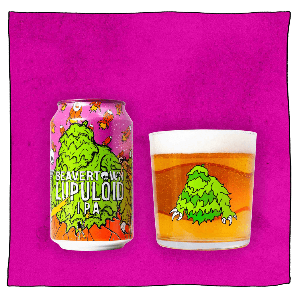 Beavertown Brewery Lupuloid IPA and Beavertown Lupuloid Tumbler glass filled with beer in front of a pink background. Beer glass is a clear glass that has a green furry monster in the centre.