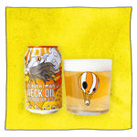 Beavertown Brewery Neck Oil IPA and Beavertown Neck Oil Tumbler glass filled with beer in front of a yellow background. Beer glass is a clear glass that has an orange and white skull themed hot air balloon in the centre.