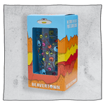 Beavertown Psychedelic pint glass inside an orange and blue box in front of a grey background. Box has artwork depicting a white UFO in an orange, yellow and red canyon with a blue sky. Psychedelic pint glass is visible in middle of box and is clear glass with colourful skulls and bones scattered all around the glass.