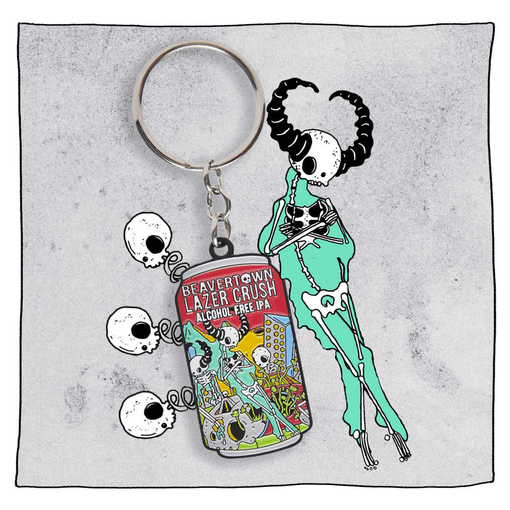 Lazer Crush Can Keyring  in front of a light grey background with illustrations of skulls and a skeleton with horns.