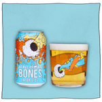 Beavertown Brewery Bones Dead Good Lager and Beavertown Half pint glass filled with beer. Blue and orange can with white skull with skeleton hands in front of a blue background. Skull only has one large eye socket which is exerting a yellow laser beam. Beavertown Half pint glass has the same one eye socket skull shooting tangled blue and orange laser beams.