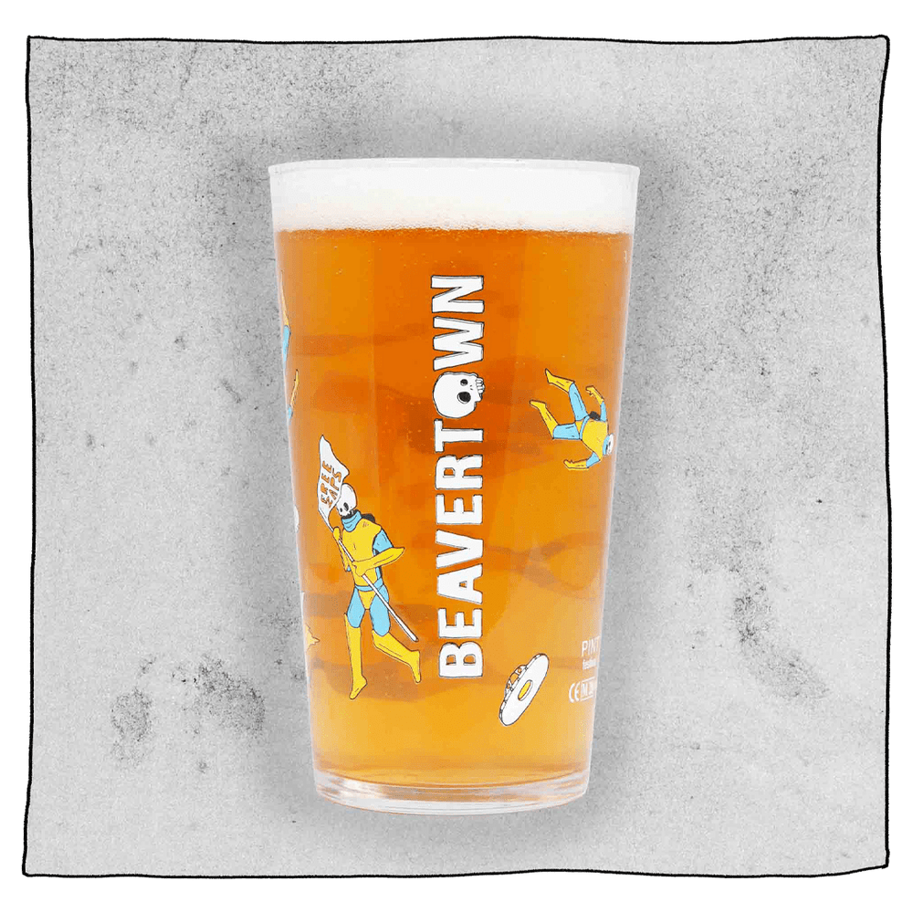 Beavertown Gamma Ray Pint Glass. Glass filled with beer and has many Gamma Ray men scattered around the glass and white Beavertown text. Grey background.