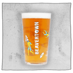 Beavertown Gamma Ray Pint Glass. Glass filled with beer and has many Gamma Ray men scattered around the glass and white Beavertown text. Grey background.