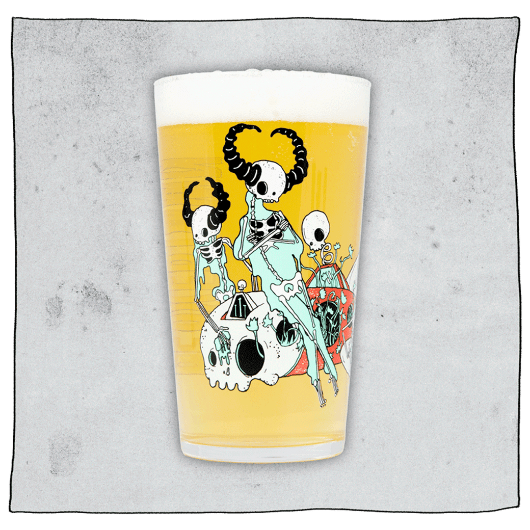 Beavertown Brewery Lazer Crush pint glass filled with beer in front of a grey background. Glass has white skeletons with black horns.