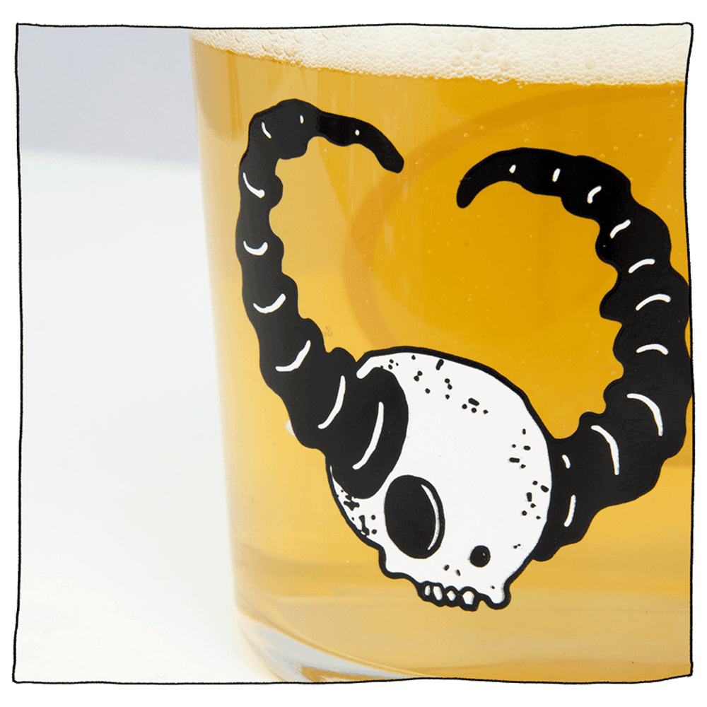 Zoomed in image on Beavertown Lazer Crush Tumbler glass with white skull and black horns filled with beer.