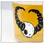 Zoomed in image on Beavertown Lazer Crush Tumbler glass with white skull and black horns filled with beer.