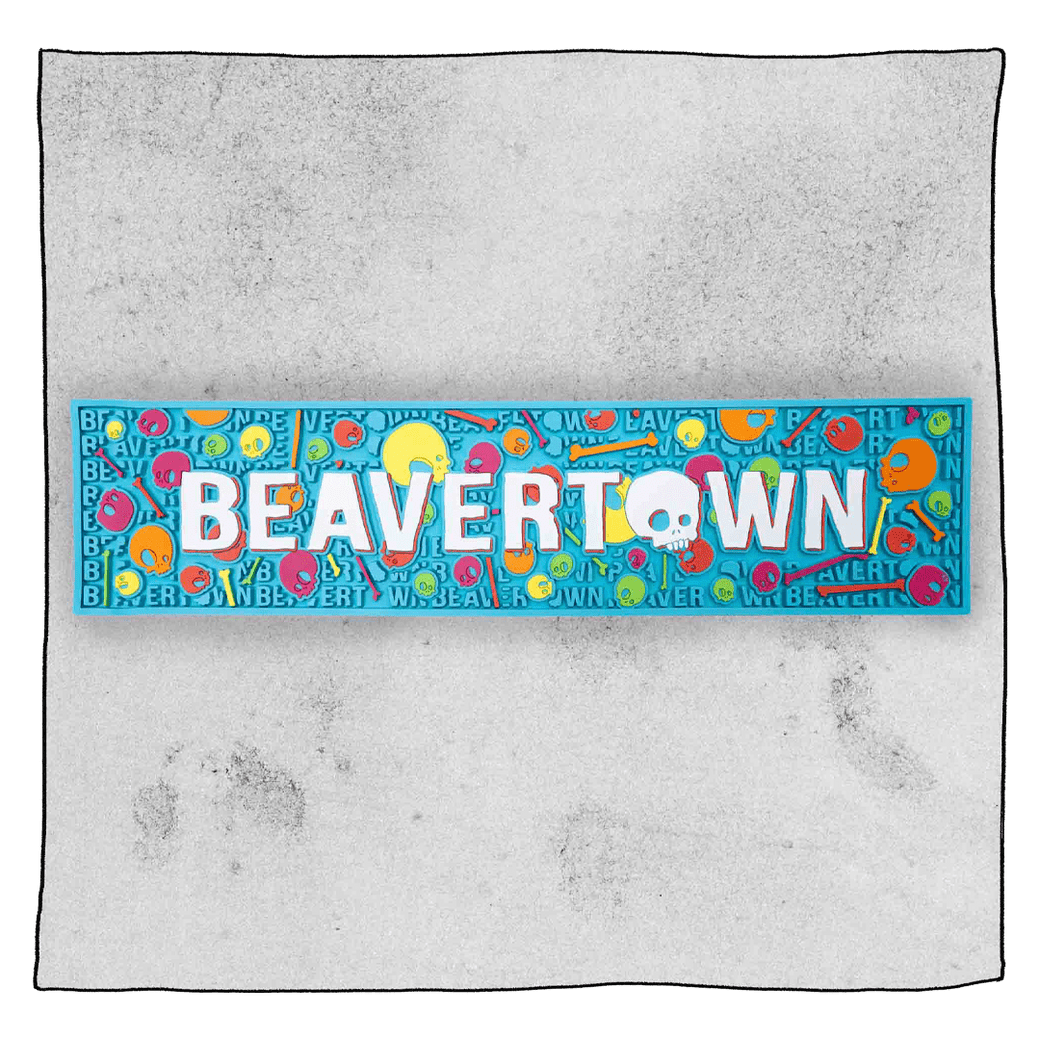 Beavertown Pschedelic Blue Bar runner in front of a grey background. Bar runner has white Beavertown text and colourful skulls and bones.